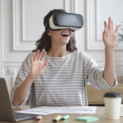 Frau mit VR Brille sitzt am Tisch
